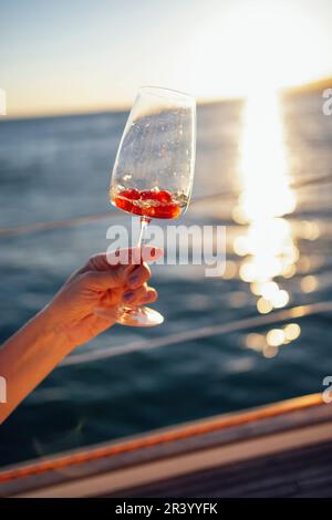 Sonnenuntergang am Himmel und Meer im Hintergrund. Wir stoßen mit Sekt an Stockfoto