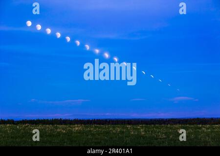 Zeitraffer-Composite des untergehenden Vollmondes, der in Alberta, Kanada, den Schirmschatten der Erde eindringt. Stockfoto