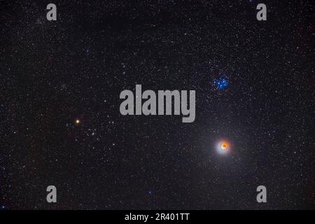 Partielle Mondfinsternis unter dem Sternenhaufen der Pleiades im Taurus. Stockfoto