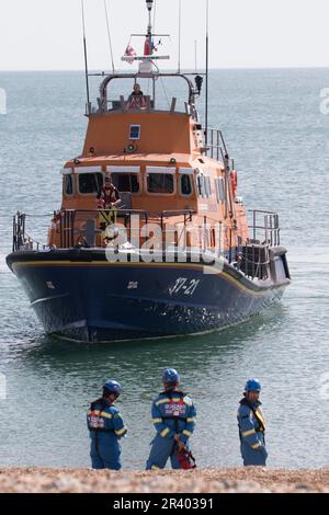 Seaford Bay, East Sussex, Großbritannien. 25. Mai 2023. Küstenwache und RNLI reagieren auf Berichte von zwei Personen, die in kleinen aufblasbaren Booten ins Meer gefegt wurden. Newhavens Allwetter-Rettungsboot zusammen mit den Bodenteams der Küstenwache und dem Hubschrauber der Küstenwache waren bald vor Ort und die beiden Personen wurden sicher an die Küste zurückgebracht. Die Teams wurden mit Applaus von denen begrüßt, die den Vorfall am Strand miterlebt haben. Kredit: Newspics UK South/Alamy Live News Stockfoto