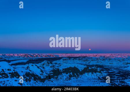 Der Vollmond erhebt sich über dem Dinosaur Provincial Park in Alberta, Kanada, am Red Deer River. Stockfoto