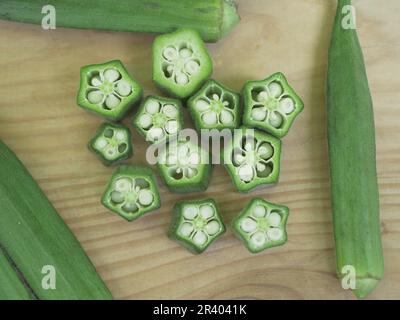 Lady's Finger, frische grüne Gemüsestückchen auf einem Holzbrett angeordnet Stockfoto