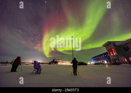 Zuschauer beobachten die Nordlichter im Churchill Northern Studies Centre in Churchill, Manitoba, Kanada. Stockfoto