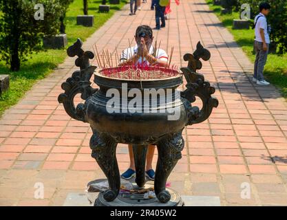 Ein buddhistischer betet mit einem Weihrauchbrenner in der Thien Mu Pagode in Hue, Vietnam. Stockfoto