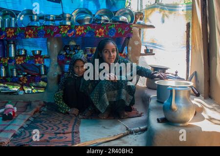 Srinagar, Indien. 25. Mai 2023. Die nomadische Familie Bakarwal aus Kashmiri bereitet Mahlzeiten zu, während sie ihr temporäres Lager am Straßenrand am Stadtrand von Pulwama, südlich von Srinagar, aufbaut. Bakarwals sind nomadische Tierhirten im Bundesstaat Jammu Kaschmir, die auf der Suche nach guten Weiden für ihre Rinder wandern. (Foto: Faisal Bashir/SOPA Images/Sipa USA) Guthaben: SIPA USA/Alamy Live News Stockfoto