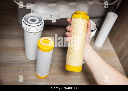 Der Installateur installiert oder wechselt den Wasserfilter. Ersatz-Aqua-Filter Stockfoto