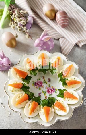 Gefüllte Eier mit Käse und gesalzener Lachs in Form einer Karotte. Festliches Abendessen, Osterbrunch. Stockfoto