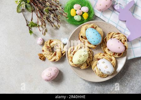 Osterkomposition. Süßes italienisches Osterbrot klingelt von Blätterteig und gefärbten Eiern auf Steinhintergrund. Blick von oben. Verstanden Stockfoto