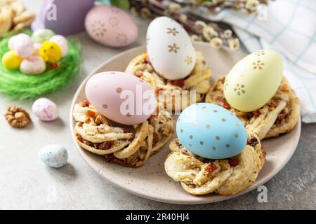 Osterkomposition. Süßes italienisches Osterbrot klingelt von Blätterteig und gefärbten Eiern auf Steinhintergrund. Stockfoto