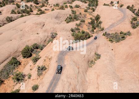 OHVs oder Off Highway-Fahrzeuge fahren über die Sandsteinkuppeln des Fins & Things Trail in der Nähe von Moab, Utah. Stockfoto