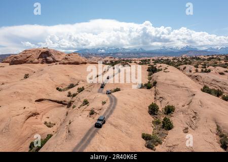 Ein Jeep & Off Highway oder OHVs fahren über die Sandsteinkuppeln des Fins & Things Trail in der Nähe von Moab, Utah. Stockfoto