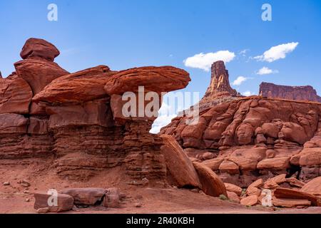 Ein Wingate Sandstone butte mit gestreiften Cutler Sandstein Felsformationen vor dem Shafer Trail bei Moab, Utah. Aber die weißen Streifen sind es Stockfoto