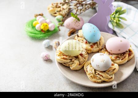 Osterkomposition. Süßes italienisches Osterbrot klingelt von Blätterteig und gefärbten Eiern auf Steinhintergrund. Speicherplatz kopieren. Stockfoto