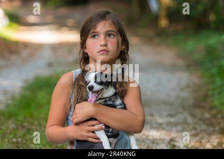 Ein hungriges, obdachloses, verlassenes Kind sucht mit seinem kleinen Hund nach Nahrung und Unterkunft Stockfoto