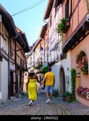 Ein Paar mit wunderschönem Blick auf die farbenfrohe romantische Stadt Eguisheim in der Nähe von Colmar, Frankreich, Elsass Stockfoto