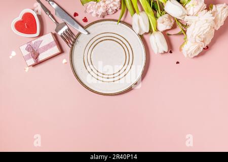 Valentinstag, Frauentag, Muttertag Grußkarte. Menü zum Valentinstag und wunderschöne Frühlingsblumen auf hellrosa Hintergrund Stockfoto