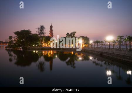 Westsee und Wasserspiegelung der beleuchteten Tran Quoc Pagode - der älteste buddhistische Tempel in Hanoi bei Abenddämmerung, Vietnam. Stockfoto