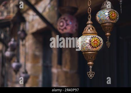 Handgefertigte traditionelle, farbenfrohe türkische Lampen und Laternen, selektiver Fokus auf Laternen, verschwommener Hintergrund, beliebte Souvenirlaternen, die im Geschäft hängen Stockfoto