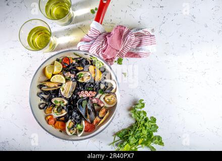 Meeresfrüchte schwarze Fettuccine fehttuchini. Schwarze Pasta mit Tintenfisch, Muscheln, Tintenfisch, Muscheln auf der Steinplatte. Gourmet Teller Stockfoto