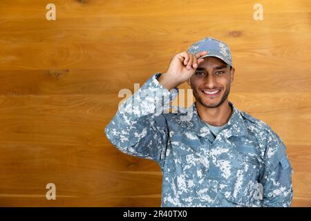 Porträt eines glücklichen, birassischen Soldaten in Uniform, der auf die Kamera schaut, die Mütze, Kopierraum Stockfoto