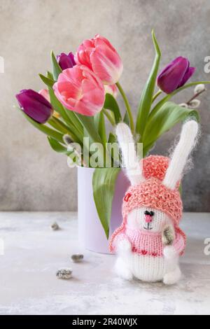 Bouquet von rosa und lila Tulpen mit bunten Wachteleiern. Konzept für Frühlings- und Osterferien. Stockfoto