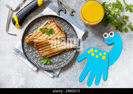 Alles gute zum Vatertag. fatherâ€™s Day Karte Dinosaurier und Heimwerkerfrühstück für Papa auf grauem Steintisch. Blick von oben. Stockfoto