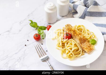 Glutenfreie Spaghetti-Pasta mit gegrilltem Lachs in Frischkäse auf Marmorhintergrund. Speicherplatz kopieren. Stockfoto