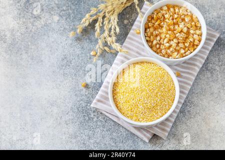 Glutenfreie Lebensmittelzutat. Grobgrieß und Samen auf grauem Steinhintergrund. Blick von oben. Speicherplatz kopieren. Stockfoto