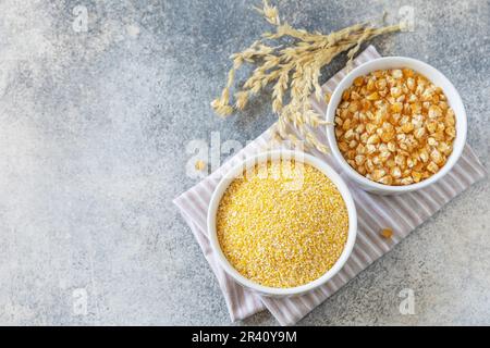 Glutenfreie Lebensmittelzutat. Grobgrieß und Samen auf grauem Steinhintergrund. Blick von oben. Stockfoto