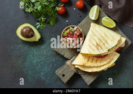 Gesundes Mittagessen. Tortilla-Sandwich, mexikanische Wraps mit gegrilltem Hühnerfilet und Avocado, serviert mit Guacamole. Blick von oben Stockfoto