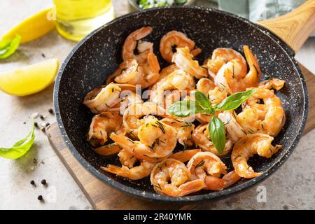 Scharfe Knoblauch-Chili-Garnelen gekochte Garnelen und Kräuter, Garnelen in einer Pfanne mit Zitrone. Meeresfrüchte, Schalentiere. Stockfoto