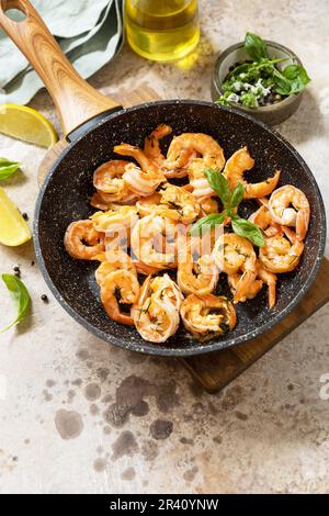 Scharfe Knoblauch-Chili-Garnelen gekochte Garnelen und Kräuter, Garnelen in einer Pfanne mit Zitrone. Meeresfrüchte, Schalentiere. Speicherplatz kopieren. Stockfoto