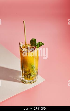 Kalter alkoholischer oder alkoholfreier Cocktail mit pastellfarbenem Hintergrund. Hartes Licht, tiefer Schatten. Stockfoto