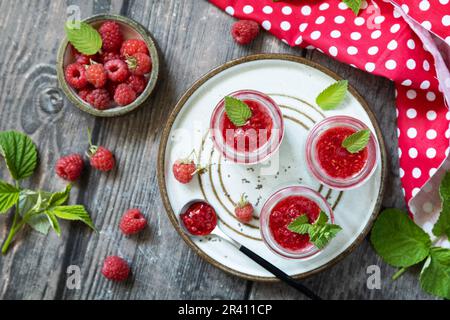 Gesundes Frühstück. Glasgefäße mit Chia-Pudding mit Himbeere und Marmelade oder Smoothies mit Chiasamen auf einem rustikalen Tisch. Ansicht von einem Stockfoto