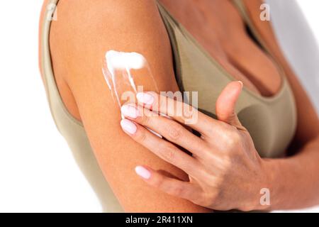 Extreme Nahaufnahme der Hände einer jungen weissen Frau mit weißer Maniküre und Creme Stockfoto