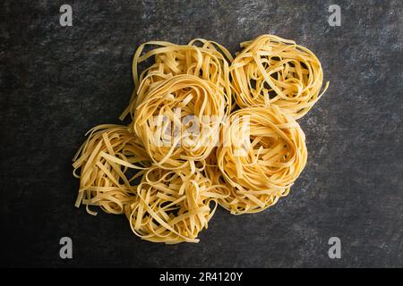 Tagliatelle Pasta Nester gestapelt und von oben betrachtet: Nester aus getrockneten Nudelnudeln stapeln sich in einer Gruppe und sehen direkt von oben Stockfoto