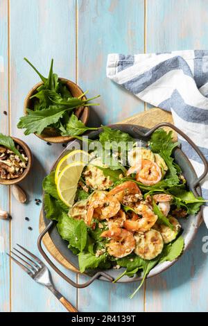 Gesundes Lebensmittelkonzept. Diät-Sommersalatplatte. Garnelensalat mit Rucola, gegrillte Zucchini und Walnuss. Blick von oben. Kopie sp Stockfoto