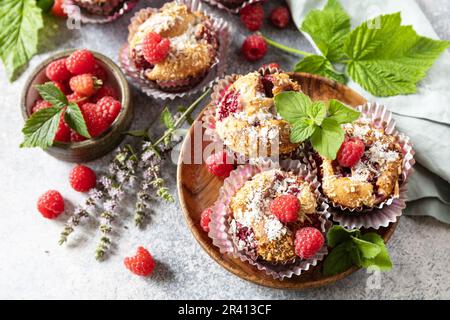 Gesundes Dessert. Veganes glutenfreies Gebäck. Haferflocken-Bananenmuffins mit Himbeer- und Kokosflocken auf einem Steintisch. Stockfoto