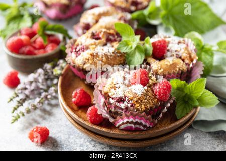 Gesundes Dessert. Veganes glutenfreies Gebäck. Haferflocken-Bananenmuffins mit Himbeer- und Kokosflocken auf einem Steintisch. Stockfoto