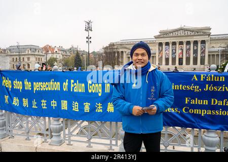 Budapest, Ungarn - 27. November 2022: Ein Demonstrator für den Falun Gong vor dem Museum der bildenden Künste auf dem Heldenplatz, auf einem bedeckten w Stockfoto