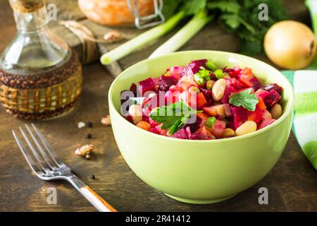 Rote Beete Salat Vinaigrette mit Sauerkraut, eingelegter Gurke und Gemüse auf einem rustikalen Holztisch. Stockfoto