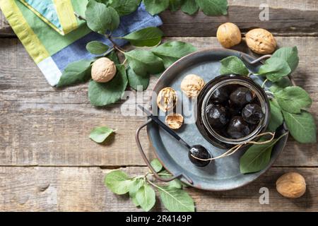 Handgemachte Marmelade aus frischen grünen Walnüssen auf Holzhintergrund. Bio-Walnussmarmelade, gesundes Essen. Blick von oben. Speicherplatz kopieren Stockfoto