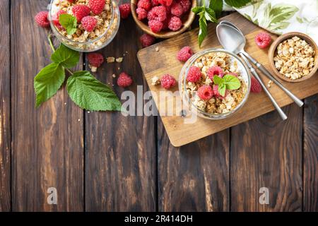 Gesundes Frühstücksmenü. Hausgemachtes Müsli-Frühstück. Ein Glas Parfait aus Müsli, Beeren, Himbeeren, Joghurt mit ch Stockfoto
