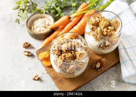 Gesundes Dessert. Veganes glutenfreies Gebäck. Karottenkuchen mit Walnüssen und Zimt in einem Glas auf hellem Hintergrund. Speicherplatz kopieren. Stockfoto