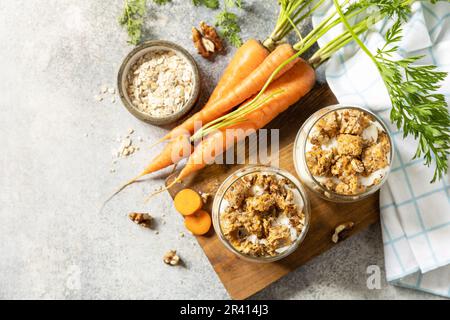 Veganes glutenfreies Backen. Karottenkuchen mit Walnüssen und Zimt in einem Glas auf hellem Hintergrund. Gesundes Dessert. Blick von ABO Stockfoto