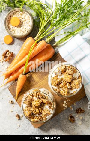 Veganes glutenfreies Backen. Karottenkuchen mit Walnüssen und Zimt in einem Glas auf hellem Hintergrund. Gesundes Dessert. Blick von ABO Stockfoto