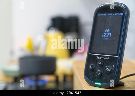 London, Großbritannien. 22. Mai 2023. Ein intelligenter Zähler in einer Küche sitzt auf einem Brotbehälter und erfasst die täglichen Gas- und Stromkosten, mit einem Kochfeld und einem gelben Wasserkocher auf der Küchentheke im Hintergrund. Die Energieregulierungsbehörde Ofgem hat soeben die Obergrenze für die Energiepreise gesenkt, wodurch ein durchschnittlicher Kunde £426 US-Dollar pro Jahr einsparen wird. Kredit: Anna Watson/Alamy Live News Stockfoto