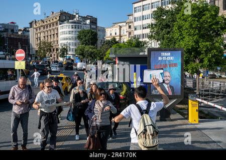 Istanbul, Türkei. 25. Mai 2023. Ein Reiseleiter sah eine Touristengruppe vor dem Werbetoster von Kemal Kilicdaroglu, Präsident des Präsidentschaftskandidaten, Republikanische Volkspartei (CHP), im Stadtteil Karakoy in Istanbul. Die Bürger werden am 28. Mai 2023 für die Präsidentschaftswahlen 2. Runde abstimmen, bei denen der Präsident der Republik Türkei, Recep Tayyip Erdogan, und der Vorsitzende der Opposition, der Vorsitzende der Republikanischen Volkspartei (CHP), Kemal Kilicdaroglu, kandidieren. Kredit: SOPA Images Limited/Alamy Live News Stockfoto