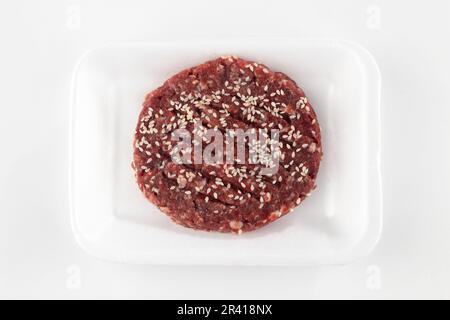 Rohe Hamburger-Pasteten mit Sesamsamen, isoliert auf weißem Hintergrund Stockfoto