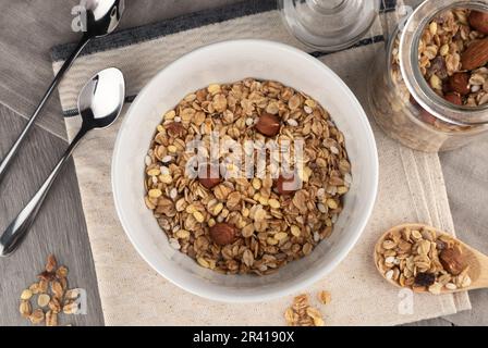Hausgemachtes Müsli mit Nüssen und Honig in einer Schüssel auf dem Tisch Stockfoto